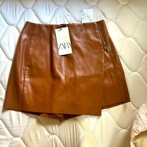 High-waisted skirt pants with pleated crossover front.